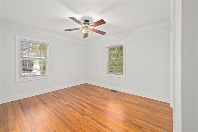 spare room featuring hardwood / wood-style flooring, ceiling fan, crown molding, and a healthy amount of sunlight