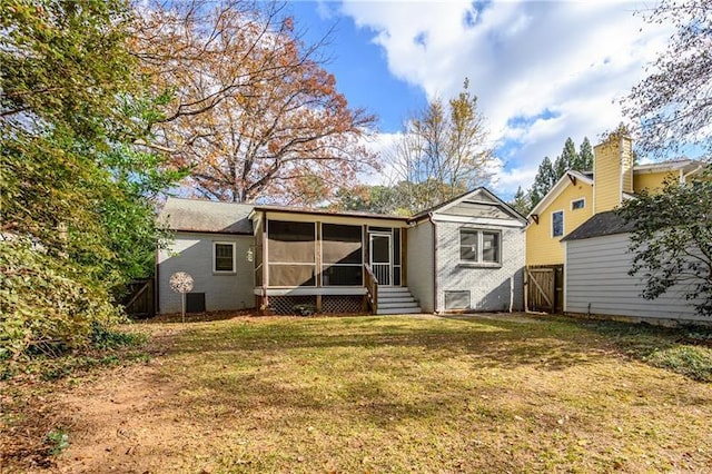 back of property with a yard and a sunroom