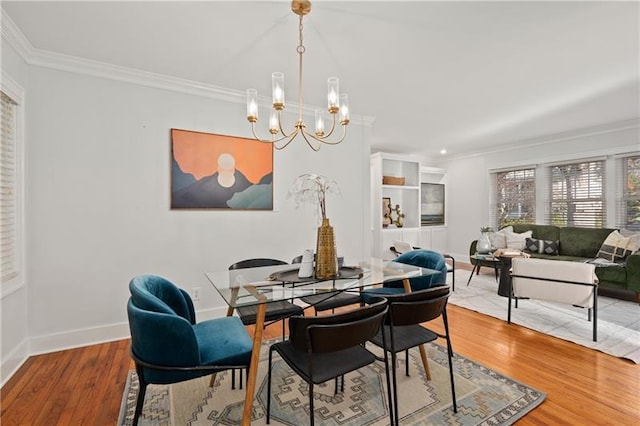 dining area featuring an inviting chandelier, crown molding, and hardwood / wood-style flooring