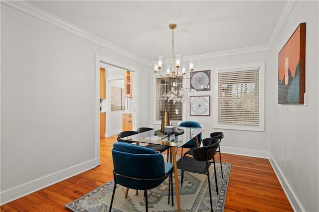 dining space with a chandelier, crown molding, and wood-type flooring