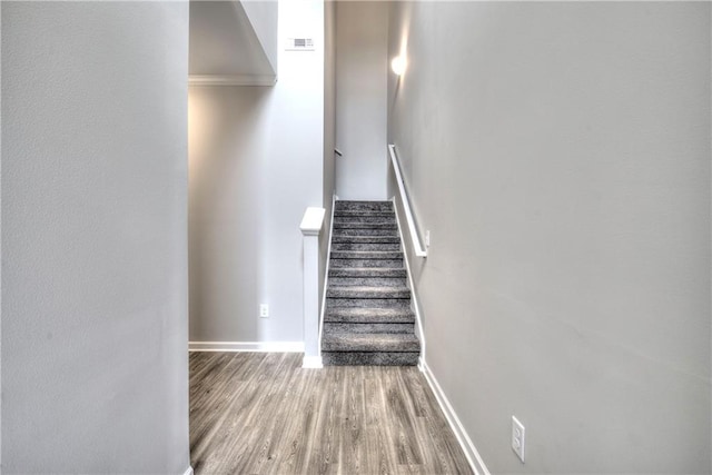 stairs with crown molding and hardwood / wood-style floors