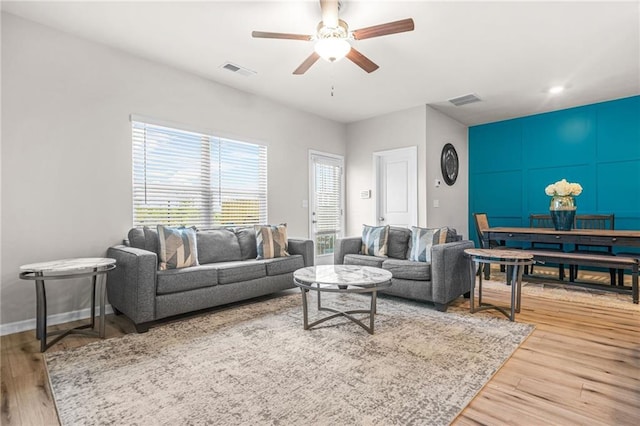 living area with wood finished floors, visible vents, and ceiling fan