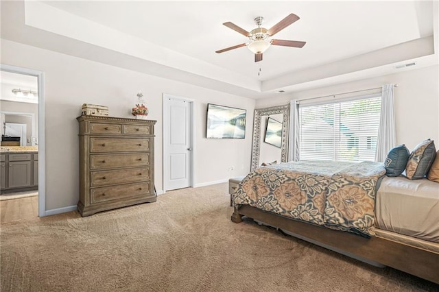 bedroom with visible vents, light carpet, a raised ceiling, and baseboards