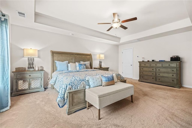bedroom featuring ceiling fan, a raised ceiling, visible vents, carpet, and baseboards