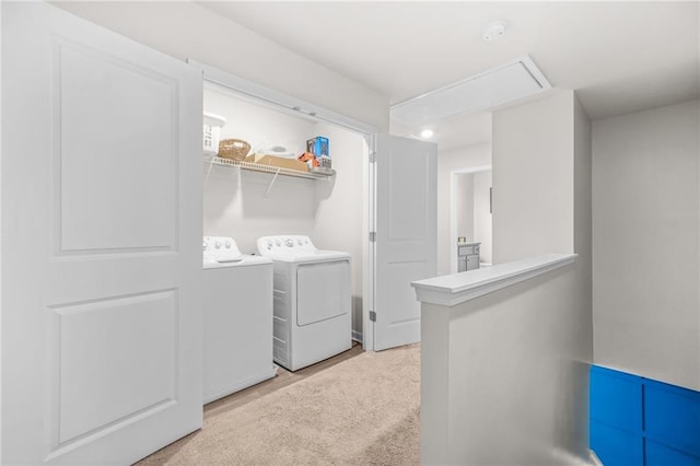 clothes washing area featuring washer and dryer, attic access, and laundry area