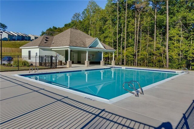 community pool featuring a patio and fence