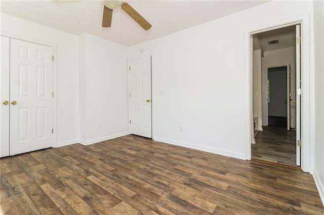 unfurnished bedroom featuring a ceiling fan, baseboards, dark wood-style floors, and visible vents