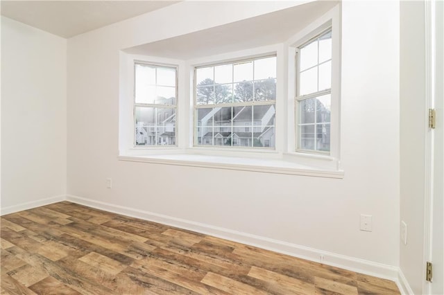 unfurnished room featuring baseboards and wood finished floors