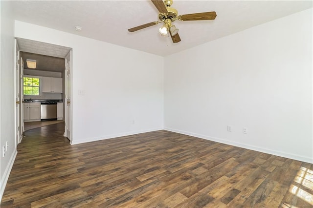 spare room featuring dark wood-type flooring, baseboards, and a ceiling fan