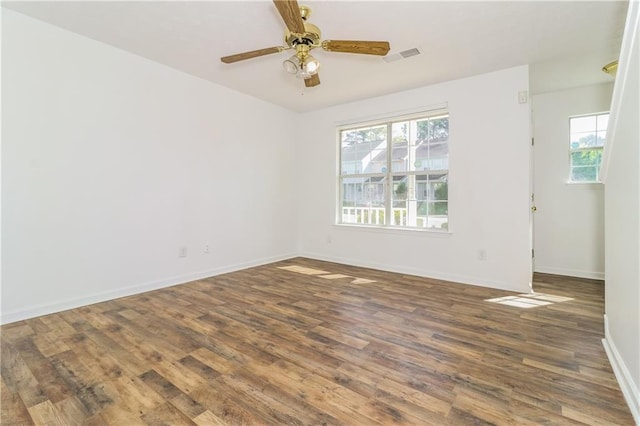 spare room with ceiling fan, baseboards, visible vents, and wood finished floors