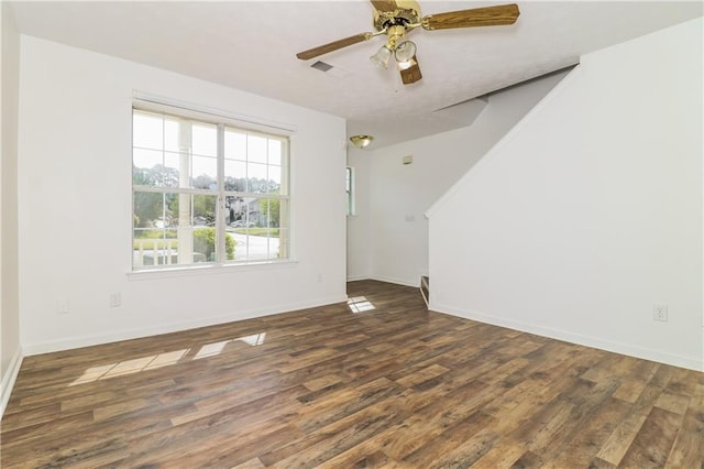 empty room featuring visible vents, baseboards, a ceiling fan, and wood finished floors