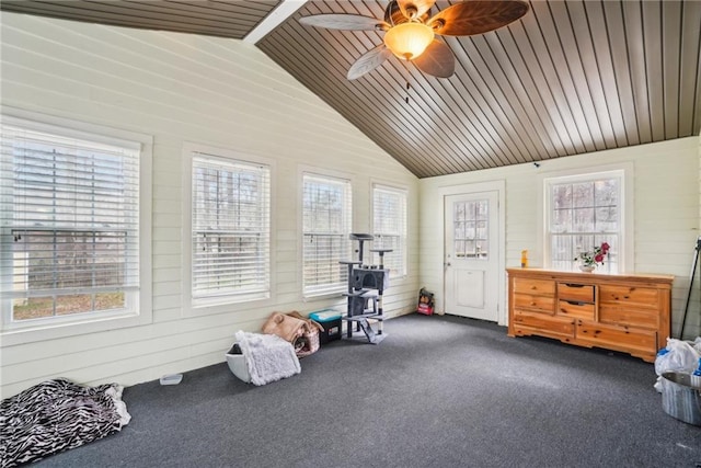 interior space featuring vaulted ceiling, dark carpet, wood ceiling, and wooden walls