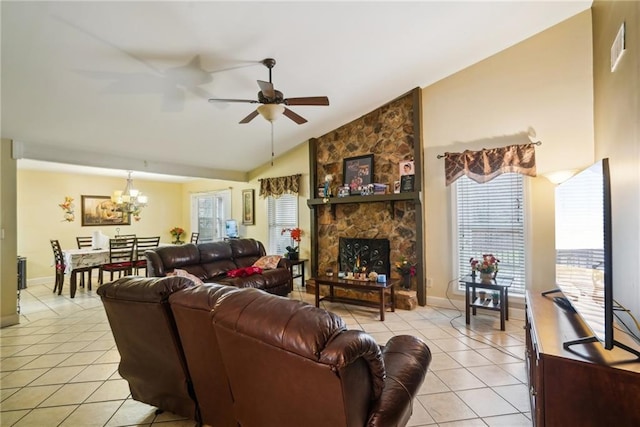 living area with light tile patterned floors, ceiling fan with notable chandelier, a fireplace, baseboards, and vaulted ceiling