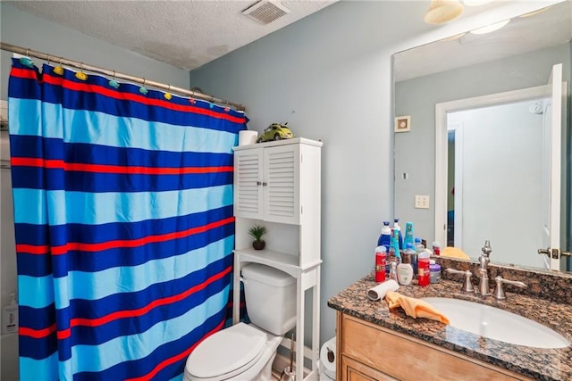 bathroom featuring visible vents, toilet, curtained shower, a textured ceiling, and vanity