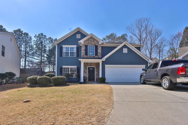 view of front of property featuring a front lawn, a garage, stone siding, and driveway