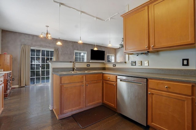 kitchen with dark wood finished floors, a peninsula, stainless steel dishwasher, hanging light fixtures, and a sink