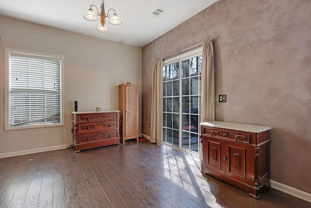 living area featuring dark wood finished floors, an inviting chandelier, baseboards, and visible vents