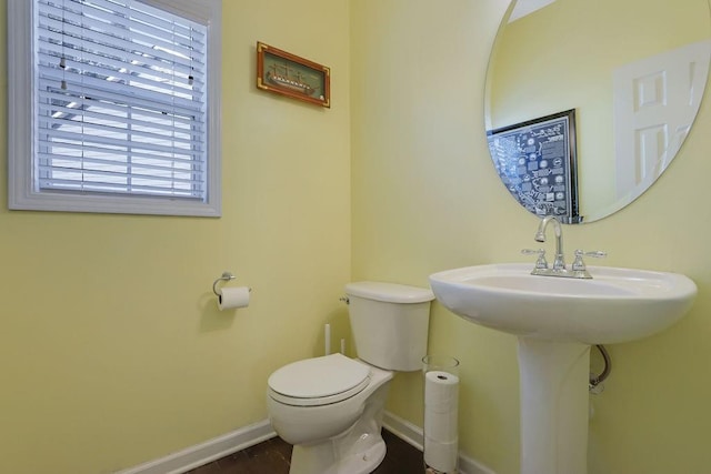 bathroom featuring toilet and baseboards