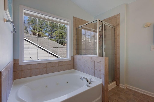 full bath featuring baseboards, a healthy amount of sunlight, a stall shower, and a tub with jets