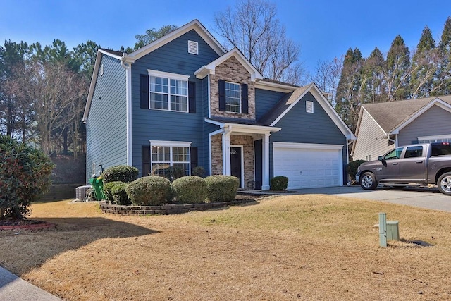 traditional-style house featuring a garage, a front lawn, and driveway