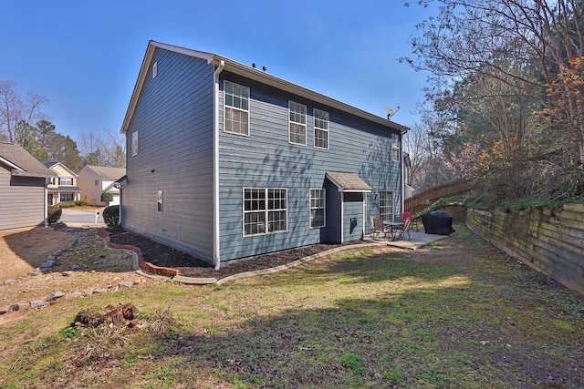 back of property with a patio area, a yard, and fence