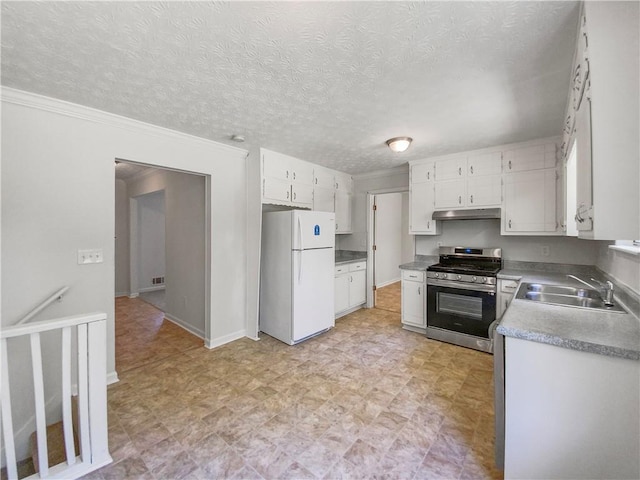 kitchen featuring light tile patterned floors, gas range, sink, and white fridge