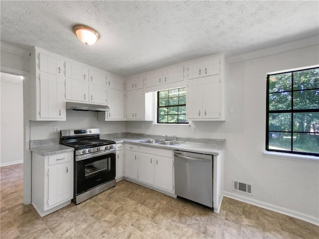 kitchen with light tile patterned floors, appliances with stainless steel finishes, sink, and plenty of natural light