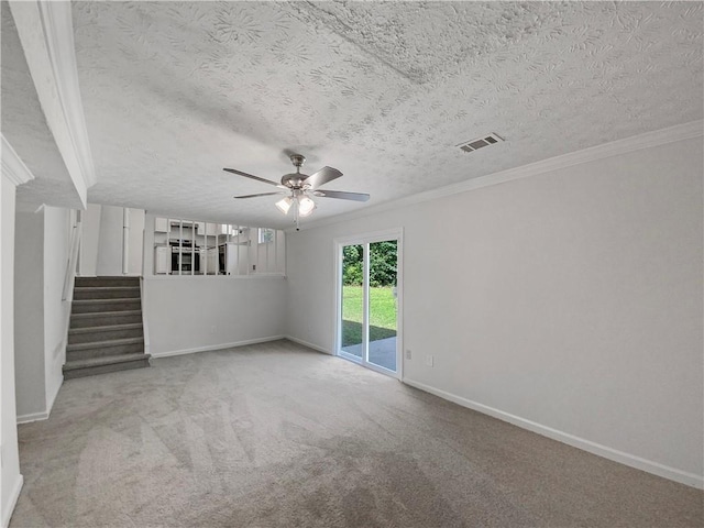 empty room featuring ceiling fan, crown molding, a textured ceiling, and light colored carpet