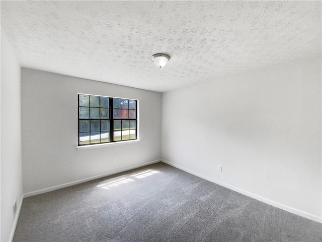 carpeted empty room featuring a textured ceiling