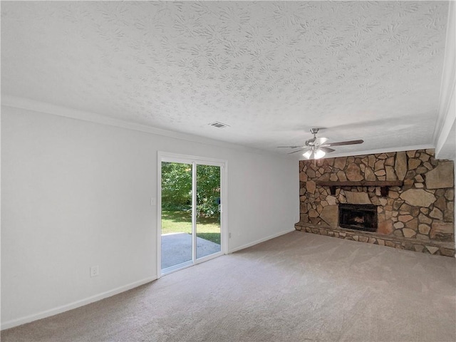 unfurnished living room with ceiling fan, a fireplace, a textured ceiling, and carpet floors