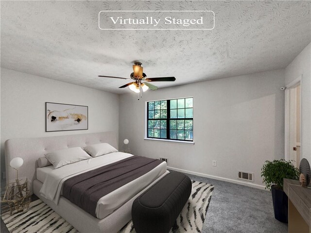 carpeted bedroom featuring ceiling fan and a textured ceiling