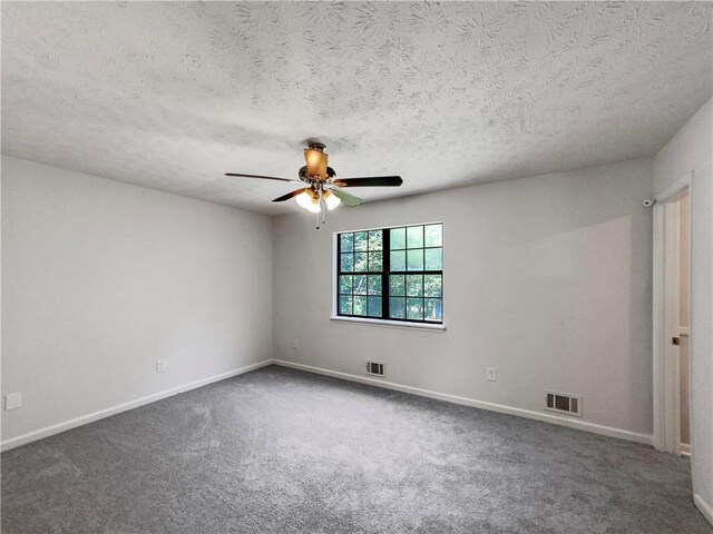 empty room featuring carpet floors, ceiling fan, and a textured ceiling