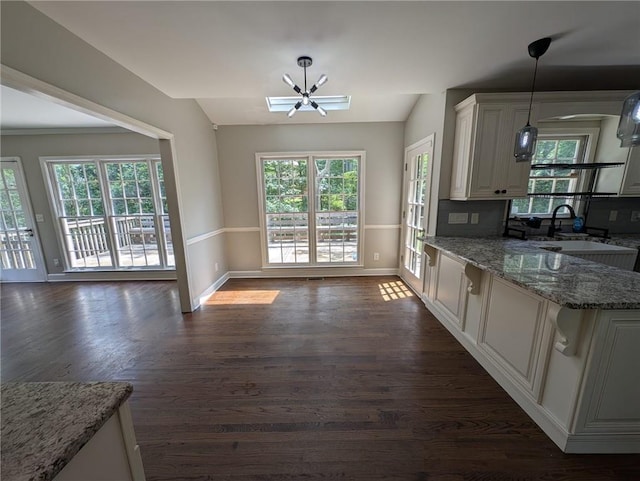 5882 Grandview Ct NW, Acworth, GA 30101 - kitchen with a chandelier, dark wood finished floors, light stone countertops, plenty of natural light, and vaulted ceiling