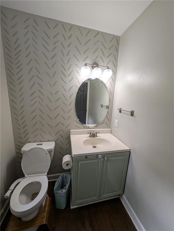 5882 Grandview Ct NW, Acworth, GA 30101 - half bathroom featuring wallpapered walls, vanity, an accent wall, and wood finished floors