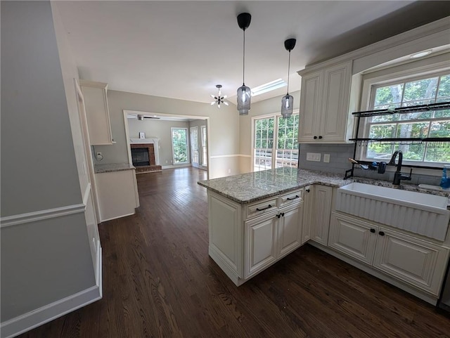5882 Grandview Ct NW, Acworth, GA 30101 - kitchen with a brick fireplace, healthy amount of natural light, dark wood-style floors, and backsplash