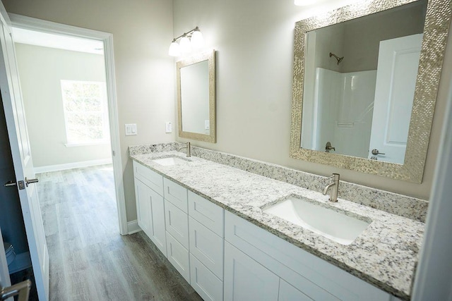 bathroom with hardwood / wood-style flooring, vanity, and walk in shower