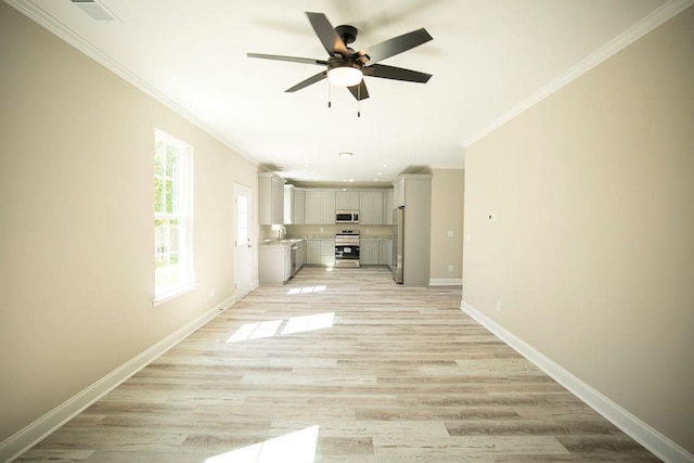 unfurnished living room featuring sink, ornamental molding, ceiling fan, and light wood-type flooring