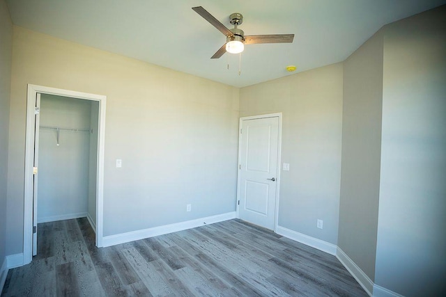 unfurnished bedroom featuring hardwood / wood-style flooring, ceiling fan, and a closet