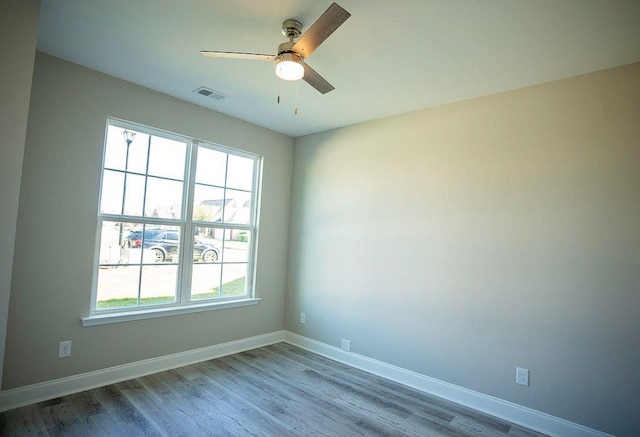 spare room with hardwood / wood-style floors and ceiling fan