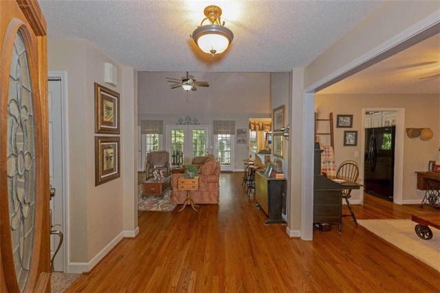 entryway featuring a textured ceiling, french doors, hardwood / wood-style floors, and ceiling fan