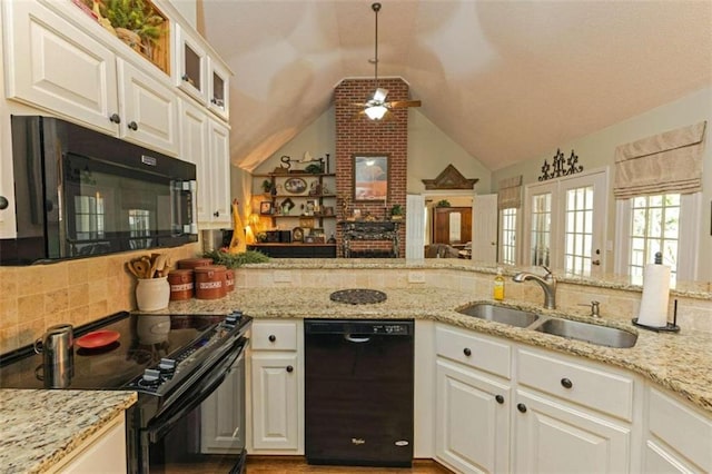 kitchen with black appliances, ceiling fan, brick wall, sink, and lofted ceiling