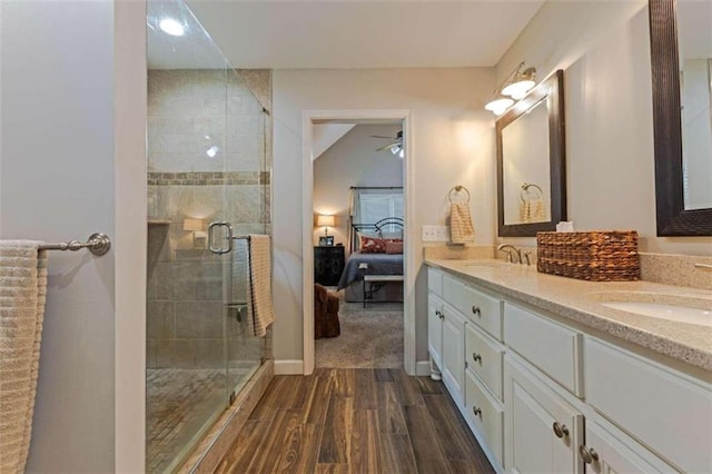 bathroom featuring ceiling fan, dual vanity, wood-type flooring, and an enclosed shower