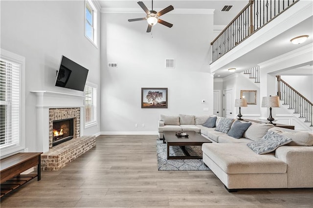 348 Meeler Cir, Bogart, GA 30622 - living area with ceiling fan, a towering ceiling, a fireplace, stairs, and wood finished floors