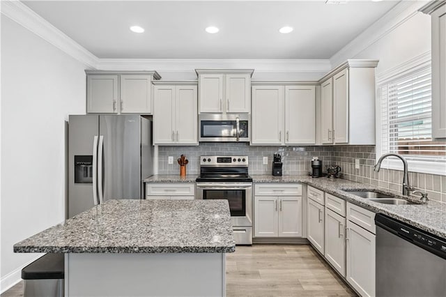 348 Meeler Cir, Bogart, GA 30622 - kitchen featuring stainless steel appliances, light wood finished floors, ornamental molding, a kitchen island, and light stone countertops