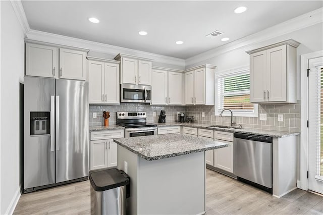 348 Meeler Cir, Bogart, GA 30622 - kitchen with stainless steel appliances, ornamental molding, light stone counters, a kitchen island, and tasteful backsplash