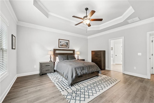 348 Meeler Cir, Bogart, GA 30622 - bedroom featuring a tray ceiling, wood finished floors, crown molding, ensuite bathroom, and a ceiling fan