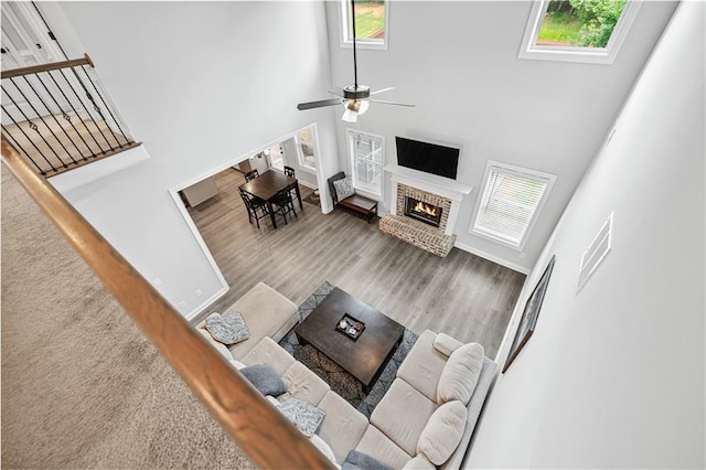 348 Meeler Cir, Bogart, GA 30622 - living area featuring plenty of natural light, a towering ceiling, ceiling fan, a fireplace, and wood finished floors