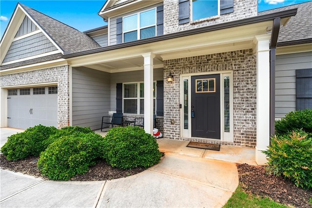 348 Meeler Cir, Bogart, GA 30622 - property entrance featuring brick siding, a porch, roof with shingles, and an attached garage