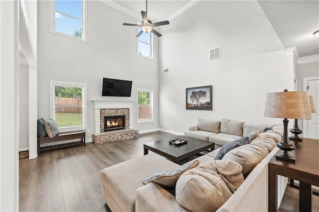 348 Meeler Cir, Bogart, GA 30622 - living room with ceiling fan, ornamental molding, a fireplace, a towering ceiling, and wood finished floors