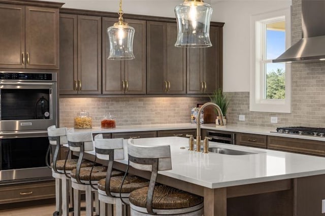 5247 Flannery Chase SW, Powder Springs, GA 30127 - kitchen featuring wall chimney exhaust hood, appliances with stainless steel finishes, light countertops, a sink, and pendant lighting